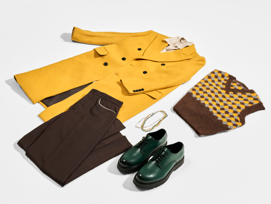 Dapper outfit laid out with dijon yellow jacket, brown slacks, brown and dijon sweater vest, and green leather shoes